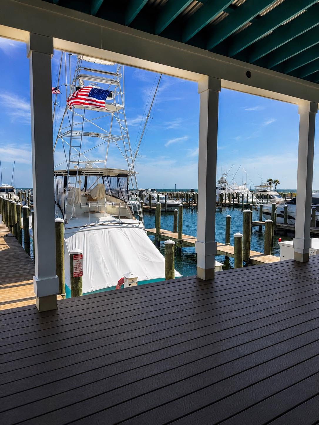 View from a covered porch across the Port Saint Joe marina, with sportfishing boats at the docks.